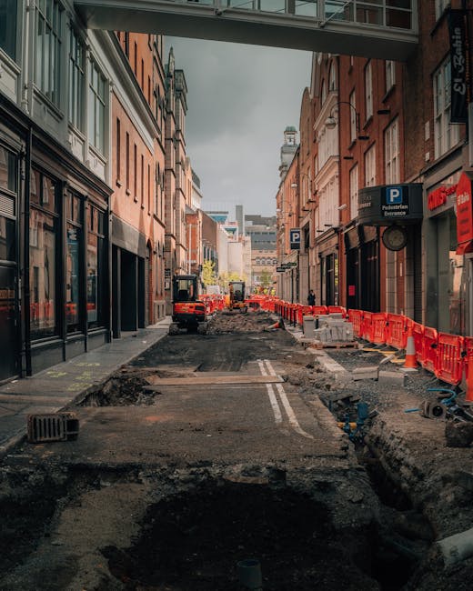 A narrow street in Fulham with a curved sidewalk paved with grey and beige bricks, lined by multi-storey buildings constructed from brick and stone, featuring large windows and decorative facades. On 